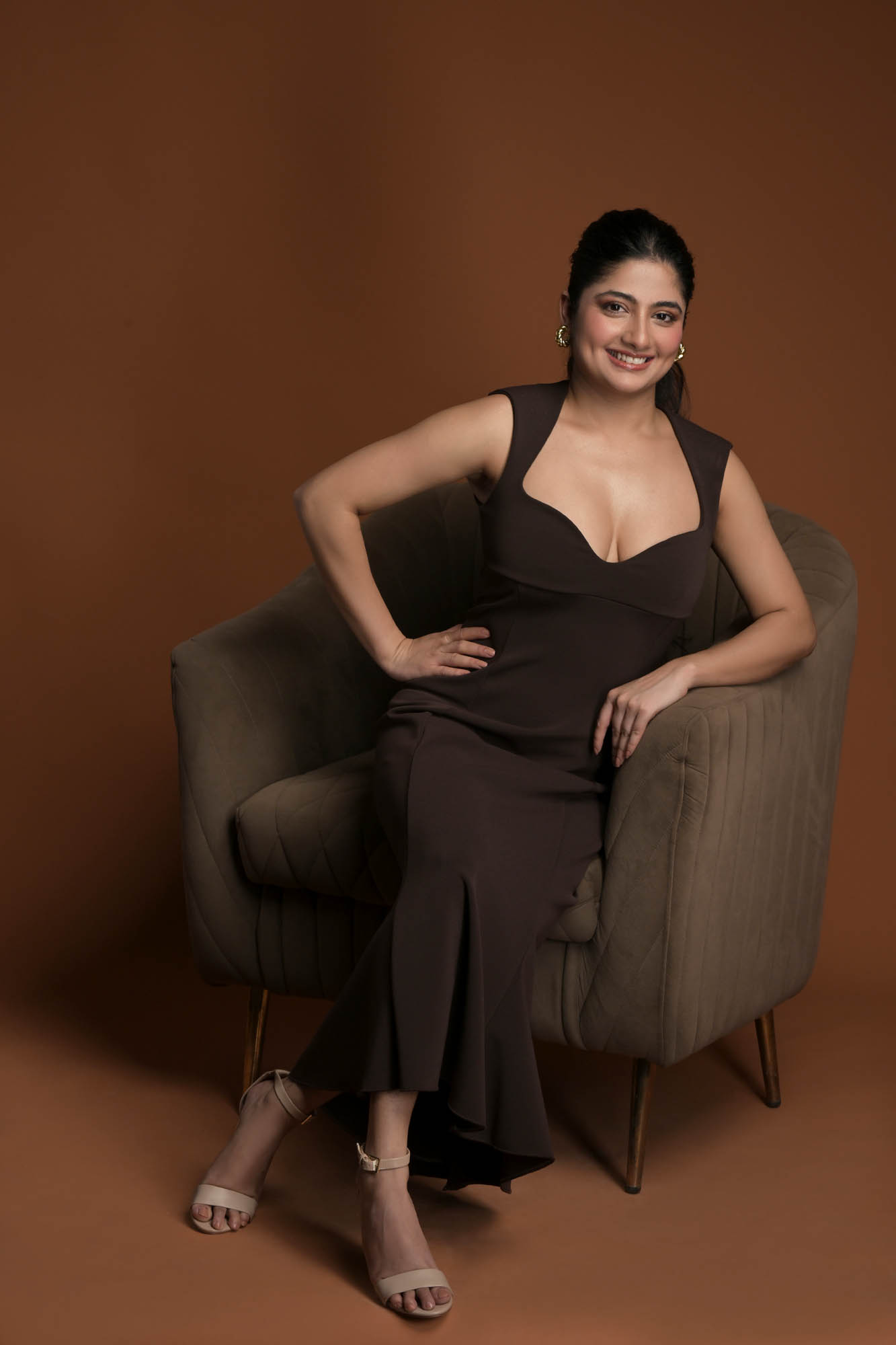 female model portfolio seated fashion portrait in floral dress on yellow background